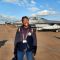 Aerospace student Favour Omolaiye standing in front of a fighter jet