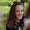 PhD student Sarah Linn smiles at camera while holding child