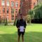 Chris standing in the courtyard at Firth Court, smiling and holding a certificate