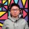 PhD student Carlo Chan against a colourful background