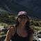 Laura Tracey sat on a rock in front of some mountains and a river