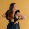 Lady in black dress facing to the side with orange background