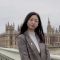A photograph of LLM student QiuYi in London standing next to the river Thames