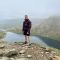 Bradley stood in a mountainous area in front of a river or lake