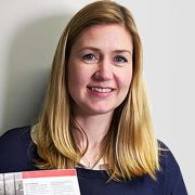 A photograph of Joanne Coster holding a printed copy of the analysis.