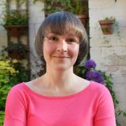 Dr Anna Krzywoszynska smiling against a flowery backdrop