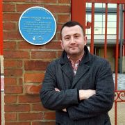 Dr Tosh Warwick next to a heritage sign for Middlesbrough Football Club