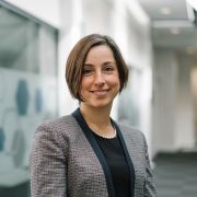 Merve Keskin wearing a black top and a grey checked jacket.