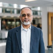 Ataur Belal wearing a checked shirt and navy jacket.