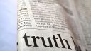 A newspaper zoomed in with the word 'truth' in large letters