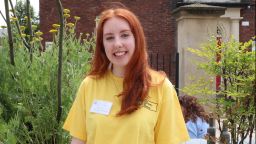 Megan Wood, English Language and Linguistics student, smiling at camera and wearing a yellow t shirt