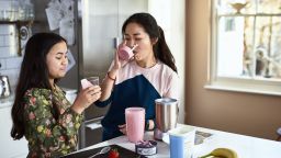 Teenage girl looking at fruit drink with satisfied expression