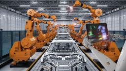 Robot arms and cars in manufacturing factory