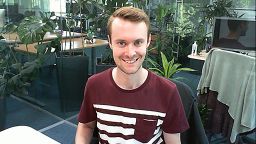 Matt sat at a desk in an office with lots of plants in the background