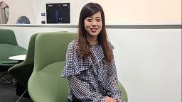 Yiyang Yan sat on a green chair smiling