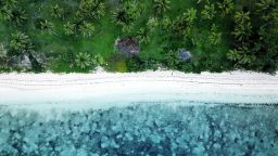 An aerial beach shot of a tropical beach with turquoise water in Fiji islands