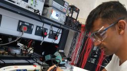 Photo showing student Rishi soldering a circuit board in the Electronics lab in the Diamond.