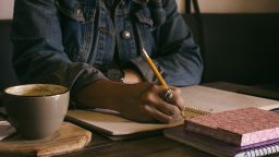 Woman writing on paper in a café