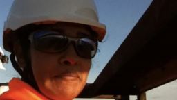 Shot of Bhavini at work in a hard hat and hi vis jacket.