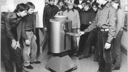 Group of students around an old robot