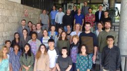 Large group of researchers facing towards camera on steps