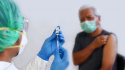Close-Up Of Doctor Preparing Syringe For Patient - stock photo