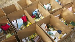 Cardboard boxes being filled with food donations - stock photo