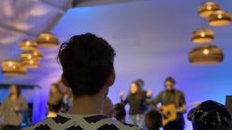 A gig goer stands and watches a live music event.