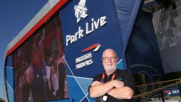 Man standing in front of Olympic screen