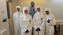 A group of students wearing protective suits for a clean room