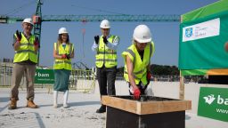 Provost and Deputy VC Gill Valentine trowels off a vessel of concrete on the top of the Social Sciences building