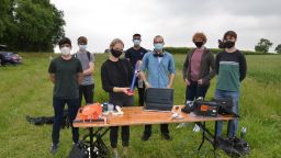 Students from the SunrIde team stood together at the launch site with the rocket