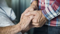 patient holding hands with a loved one