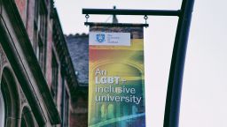 A rainbow pride banner hanging from a pole, which reads, "An LGBT+ inclusive university".