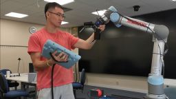 Photo of masters student Yibin Gao controlling a robot 