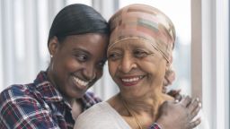 A woman with cancer being embraced by her young relative 