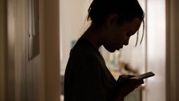 A woman checking her phone at night