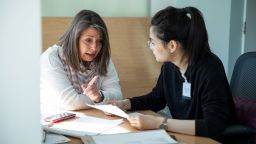 Two women talking at a table with paperwork