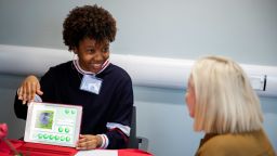 Young woman with an iPad talks to an older woman