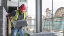 A construction worker moving a cinder block