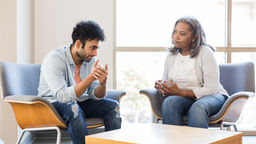 Two people sit down and to talk about mental health