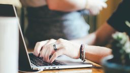 Writing on a laptop.