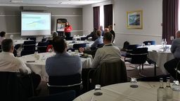 Erica Ballantyne presenting to a room of people.