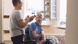 A young MND patient being cared for by their mum 