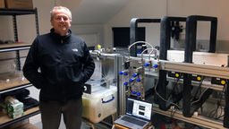 Man standing in front of medical scanner equipment