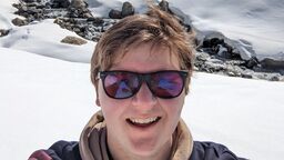 Person smiling at the camera, surrounded by snow.