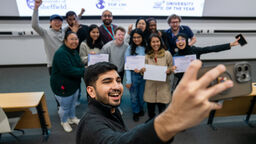 Students taking photos of winning teams 