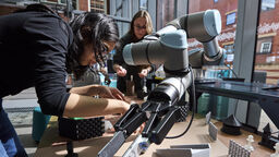 Students working with a robotic arm